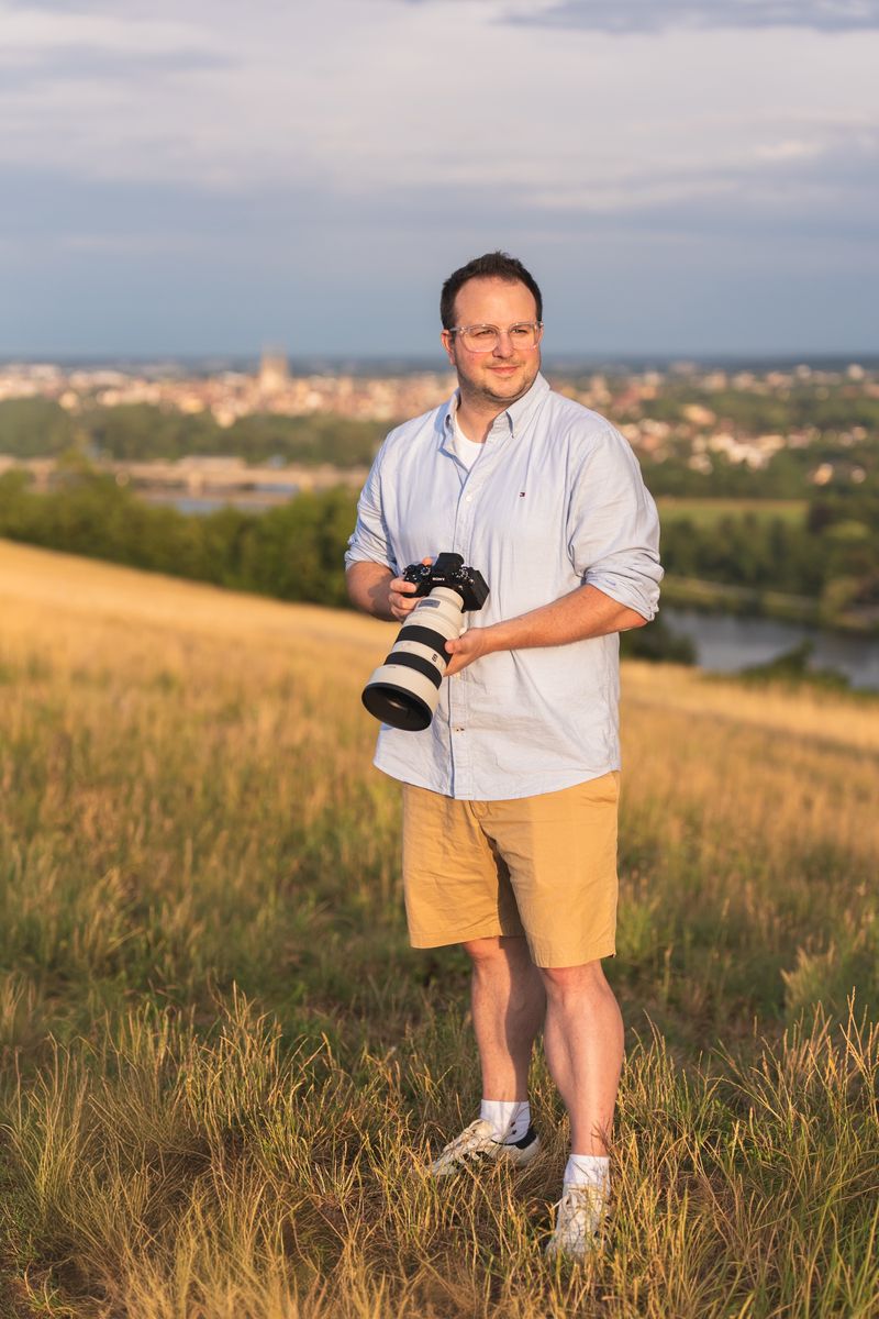 Hochzeitsfotograf Tobi Pflügl mit Sony-Kamera auf einer Wiese über Regensburg